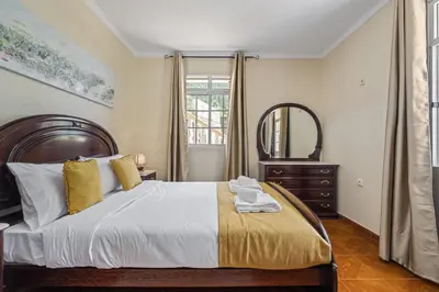 a bedroom with a large bed and a mirror at Valley Nest by Zest and Guest in Ribeira Brava