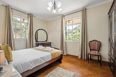 a bedroom with a bed and a chair and a mirror at Valley Nest by Zest and Guest in Ribeira Brava