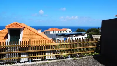 a wooden fence in front of a house at Villa Serenity in Porto Moniz