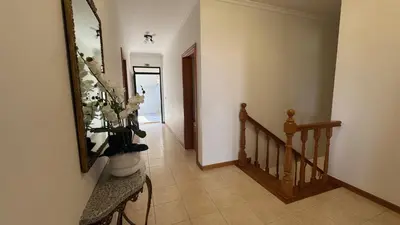 a hallway with a staircase and a vase of flowers at Villa Serenity in Porto Moniz