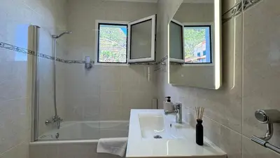 a bathroom with a sink and a shower and a tub at Villa Serenity in Porto Moniz