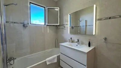 a bathroom with a sink and a tub and a mirror at Villa Serenity in Porto Moniz