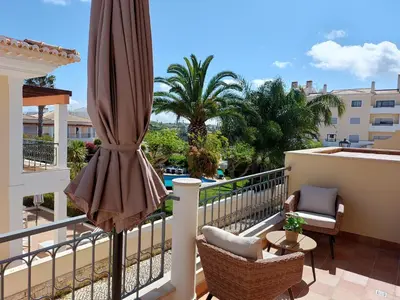 a balcony with a umbrella and chairs and a table at Lagos Bay Apartment in Lagos