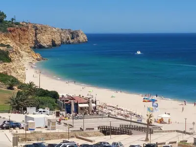 a beach with a crowd of people and the ocean at Lagos Bay Apartment in Lagos