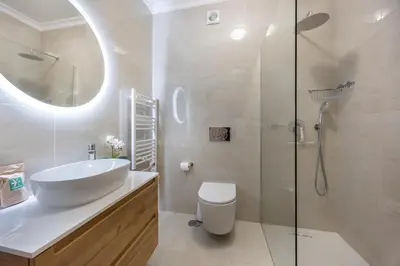 a white bathroom with a sink and a shower at Lagos Bay Apartment in Lagos