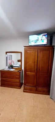 a television on top of a wooden cabinet with a mirror at Apartamento Villa 4 in Ponta do Sol