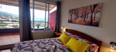 a bedroom with a bed and a large window at Apartamento Villa 4 in Ponta do Sol
