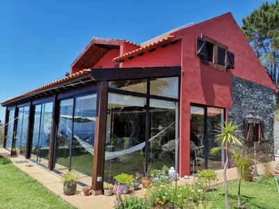 a red building with a view of the ocean at Oasis in Madeira by YMR in Raposeira do Logarinho