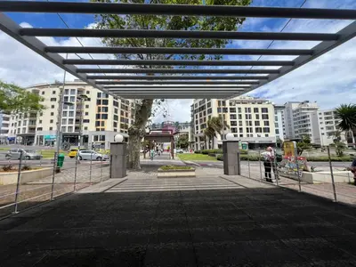 a person is standing under a metal gate in a city at Modern Urban Apartment in Funchal
