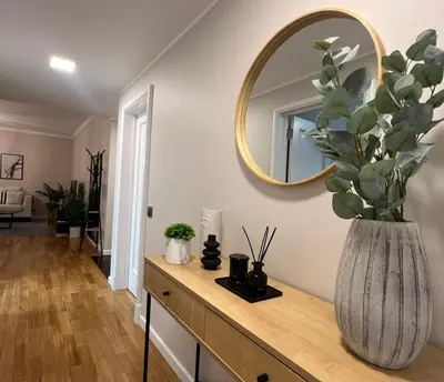 a vase with a plant on a dresser with a mirror at Modern Urban Apartment in Funchal