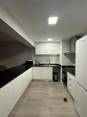 a kitchen with a black counter top and a refrigerator at Vista Marina Funchal in Funchal