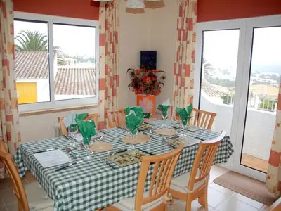 a dining room table with a green and white checkered table cloth at Villa Sorriso in Luz