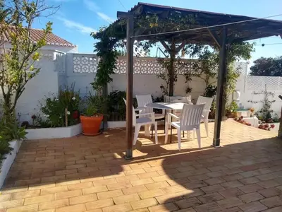 a patio with a table and chairs under a pergola at Villa Sorriso in Luz