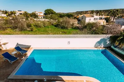 a swimming pool with a view of a villa at Fawlty Towers in Luz