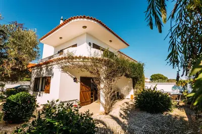 a white house with a tree in front of it at Fawlty Towers in Luz