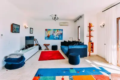 a living room with a blue couch and a red rug at Fawlty Towers in Luz