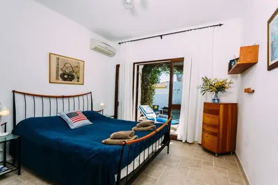 a bedroom with a bed with a blue comforter at Fawlty Towers in Luz