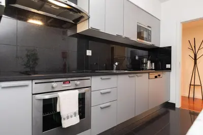 a kitchen with white cabinets and a stove top oven at Monumental Garden Loft by Rent-a-Key in Funchal
