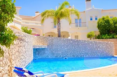 a swimming pool in front of a villa at Casa da Luz 9 , golf view townhouse in Vila do Bispo