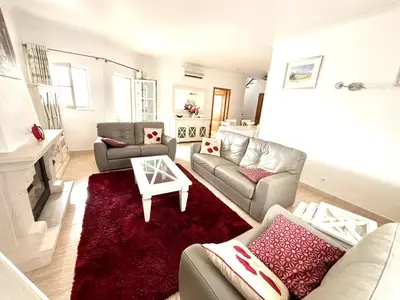 a living room with two couches and a red rug at Casa da Luz 9 , golf view townhouse in Vila do Bispo