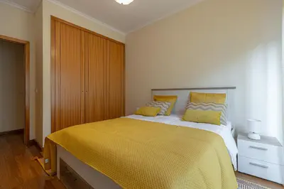 a bedroom with a large bed with a yellow bedspread at Cantinho da Ribeira in Machico