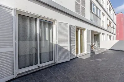 a building with sliding doors on the side of it at Cantinho da Ribeira in Machico
