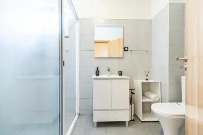 a bathroom with a toilet and a sink and a shower at Cantinho da Ribeira in Machico