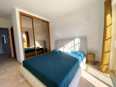 a bedroom with a blue bed and a mirror at Porto de Mós Family House in Lagos
