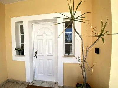 a white door with a window and a plant at Porto de Mós Family House in Lagos