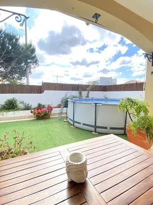 a patio table with a pool in a backyard at Porto de Mós Family House in Lagos