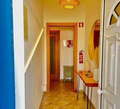 a hallway with a table and a hallway with a door at Salty & Swell Apartment in Sagres