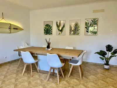 a dining room with a wooden table and chairs at Salty & Swell Apartment in Sagres