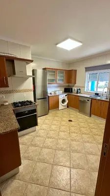 a large kitchen with wooden cabinets and stainless steel appliances at Salty & Swell Apartment in Sagres