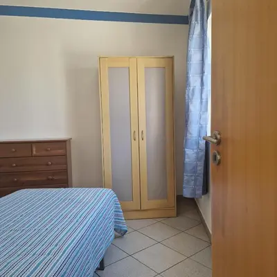 a bedroom with a bed and a wooden door at Apartamento T1 -Sagres in Sagres