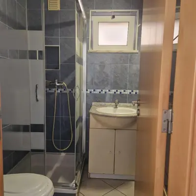 a bathroom with a sink and a shower and a toilet at Apartamento T1 -Sagres in Sagres