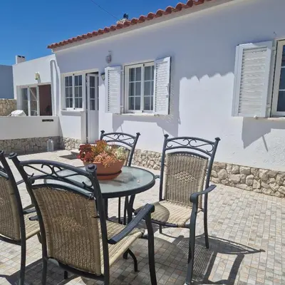 a table and chairs on a patio in front of a house at Apartamento T1 -Sagres in Sagres