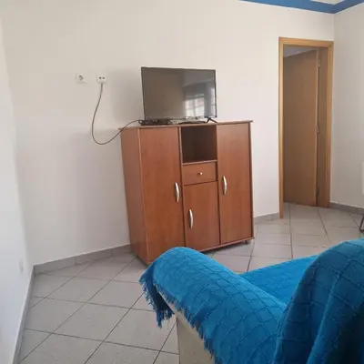a bedroom with a tv and a wooden cabinet at Apartamento T1 -Sagres in Sagres