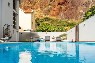 a swimming pool with a mountain in the background at Villa Salinas in Paul do Mar