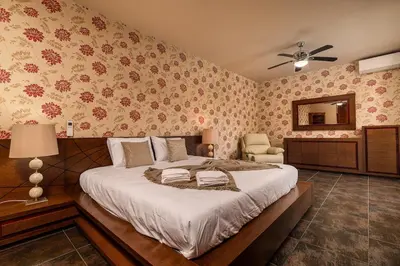 a bedroom with a large bed and a chair at Villa Salinas in Paul do Mar