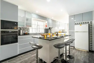 a white kitchen with a island in the middle at Villa Salinas in Paul do Mar