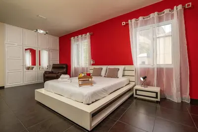 a bedroom with a large bed with red walls at Villa Salinas in Paul do Mar