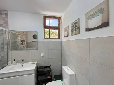 a bathroom with a sink and a toilet and a window at LUX CITYWALK Appartments AIRCON in Funchal