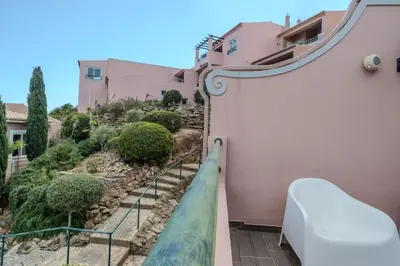 a view from the balcony of a pink house with stairs at Ocean View with Private Terrace in Luz