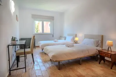 a bedroom with two beds and a table and a desk at Ocean View with Private Terrace in Luz