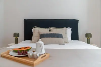a bed with a tray of fruit and a plate of food at Quintinha Estrelícia - Pool and Garden in Funchal