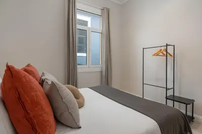 a bedroom with a bed with pillows and a window at Quintinha Estrelícia - Pool and Garden in Funchal