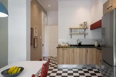 a kitchen with a table with bananas on a checkered floor at Quintinha Estrelícia - Pool and Garden in Funchal