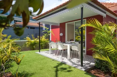 a dining area with a table and chairs in a garden at Quintinha Estrelícia - Pool and Garden in Funchal