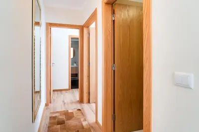 a hallway with wooden doors and a mirror at GuestReady- Charming Condo with Pool in Caniço in Caniço