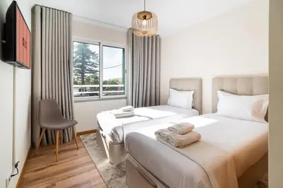 a bedroom with two beds and a window at GuestReady- Charming Condo with Pool in Caniço in Caniço